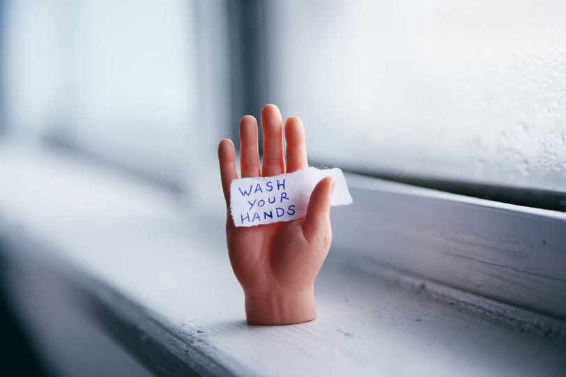 Hand, die ein Schild hält, die Hände zu waschen